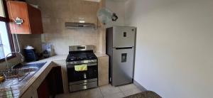 a kitchen with a refrigerator and a stove at Casa Isabella 45 AC en las habitaciones in Matagalpa