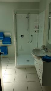 uma casa de banho com um chuveiro e um lavatório. em Ocean View Self-contained Apartment em Porirua