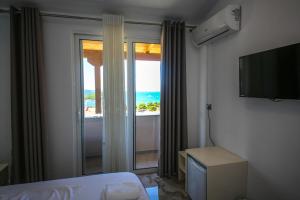 a bedroom with a window with a view of the ocean at Rumani 3 Islands Hotel in Ksamil