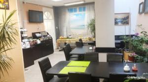 a restaurant with tables and chairs and a kitchen at Aladin Praha in Prague