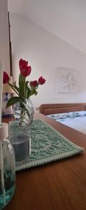 a vase of flowers on a table in a bedroom at Golden Dune View in Torre Dei Corsari