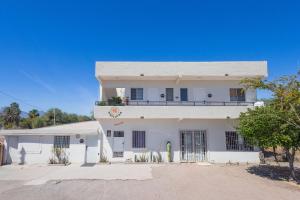 a white house with a balcony on top of it at Depas Waicura s in Loreto