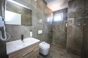 a bathroom with a sink and a shower and a toilet at Rumani 3 Islands Hotel in Ksamil