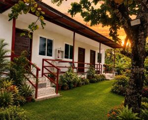 a house with a green lawn in front of it at MCRentals Siquijor in San Juan