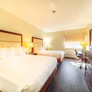 a hotel room with two beds and a desk at South Branch Inn Romney in Romney