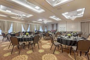 a banquet room with tables and chairs and chandeliers at Best Western PLUS The Arden Park Hotel in Stratford