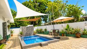 an outdoor swimming pool with an umbrella and a swimming poolvisor at Villa Ar Raudhah Kuala Terengganu in Kampong Cherong Baru +18 photos