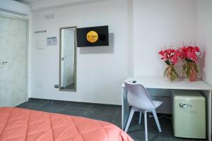 a bedroom with a desk with a chair and flowers at El Bahia Gaeta in Gaeta