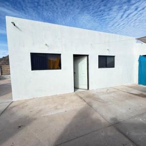 a white building with two windows and a door at Casa el palmar in Guaymas