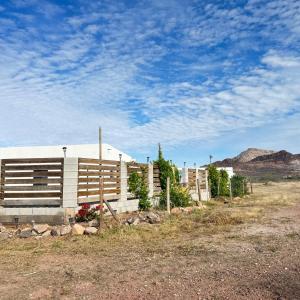 a white building with a fence in a field at Casa el palmar in Guaymas +4 photos