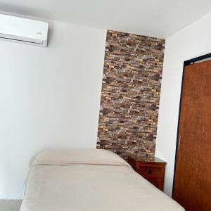a bedroom with a bed and a brick wall at Casa el palmar in Guaymas