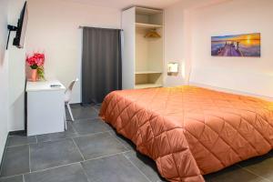 a bedroom with a bed and a table and a desk at El Bahia Gaeta in Gaeta