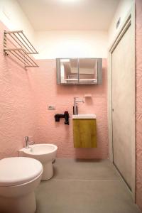 a pink bathroom with a toilet and a sink at El Bahia Gaeta in Gaeta