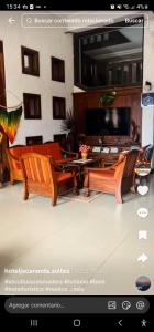 ein Screenshot einer Webseite, der ein Wohnzimmer mit Tisch und Stühlen zeigt. in der Unterkunft Hotel Jacarandá Suites in Trinidad
