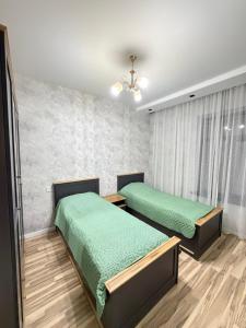 two beds in a room with green sheets at White Dream Villa in Mərdəkan +8 photos