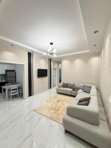 a living room with two couches and a television at White Dream Villa in Mərdəkan