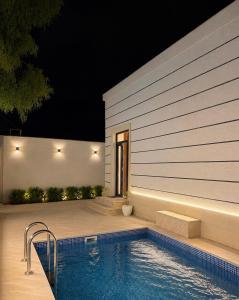 a swimming pool in front of a house at night at White Dream Villa in Mərdəkan