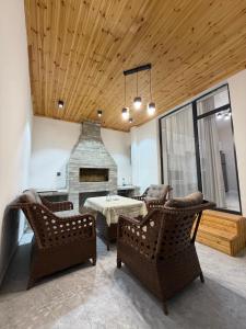 a living room with chairs and a table and a fireplace at White Dream Villa in Mərdəkan