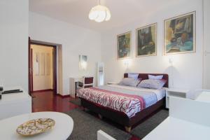um quarto com uma cama e uma mesa em White Apartment em Belgrado