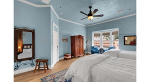 a bedroom with blue walls and a bed with a ceiling fan at Letson Loft Hotel in Bisbee