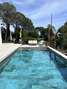 a swimming pool with blue water in a yard at La Maison du Bonheur in Saint-Raphaël