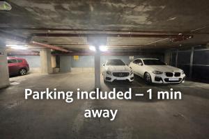 two cars are parked in a parking lot at 2BR Central Apt - Parking -2 Baths - Bars & Trains in Liverpool