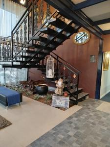 a lobby with a staircase with a bird cage and a clock at Hotel Estação Chico in Garanhuns