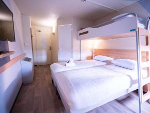 a bedroom with a bunk bed with white sheets at ibis budget Metz Sud in Augny
