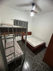a room with two bunk beds and a ceiling fan at Residencial Parque Santa Bárbara in Campinas