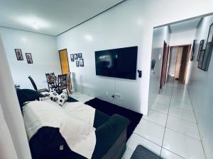 a living room with a couch and a flat screen tv at Aconchego e praticidade in Mineiros