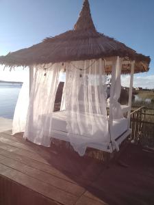 a gazebo with a thatch roof on a dock at Titicaca puma in Puno