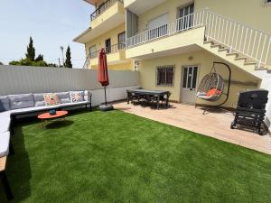 a backyard with a couch and a table and chairs at Moradia com escada, Jardim e piscina, 3Kms Praia in Almada +61 photos