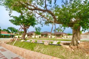 a swing in front of a house with trees at รักแรกพบรีสอร์ทสัตหีบ in Sattahip