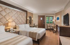 a hotel room with two beds and a television at Henann Regency Resort and Spa in Boracay