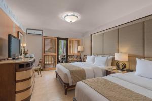 a hotel room with two beds and a flat screen tv at Henann Regency Resort and Spa in Boracay
