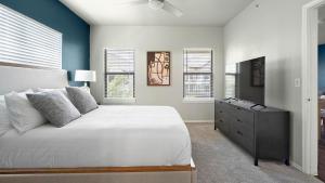a bedroom with a bed and a dresser and windows at Landing Spectacular 1BD Pool Gym in San Antonio +61 photos
