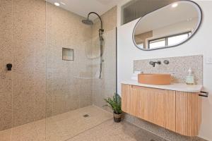 a bathroom with a shower with a sink and a mirror at The Crows Nest Eden in Eden +13 photos