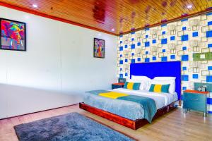 a bedroom with a king sized bed with a blue headboard at Kitumo Mara Lodges in Mara Simba