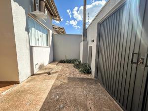 a walkway next to a building with a fence at Rosa Serena - Conforto, silêncio e garagem - Casa com 2 quartos, próximo a rodoviária e aeroporto in Palmas