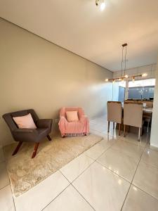 a living room with two chairs and a table at Rosa Serena - Conforto, silêncio e garagem - Casa com 2 quartos, próximo a rodoviária e aeroporto in Palmas