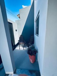 a hallway with two chairs and a potted plant at Aconchego e praticidade in Mineiros