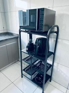 two microwaves on a stand in a kitchen at Aconchego e praticidade in Mineiros