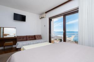 a bedroom with a bed and a view of the ocean at Apartments Vedra in Baška Voda