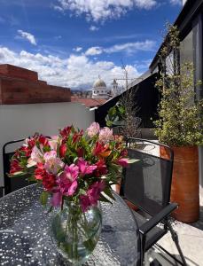 a vase of flowers sitting on a table on a balcony at CASA LAURA hotel & suites in Cuenca
