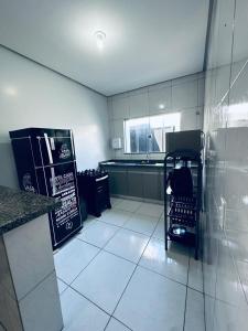 a kitchen with a counter and a sink and a kitchen with a counter at Aconchego e praticidade in Mineiros +11 photos