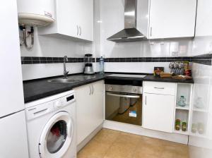 a white kitchen with a sink and a washing machine at Brisa del Mar - 2 min playa in El Ejido