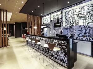eine Lobby mit einer Bar mit Stühlen und einer mit Graffiti bedeckten Wand in der Unterkunft ibis Sinop in Sinop