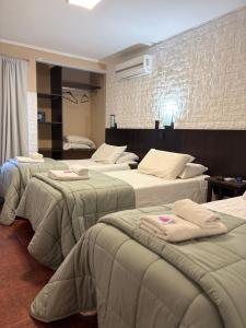 a hotel room with three beds with towels on them at Posada Bambys in Concordia +32 photos