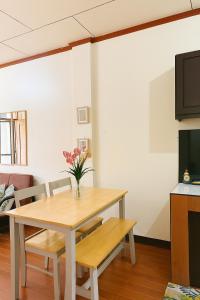 a dining room table with a vase of flowers on it at Audi's Serviced Apartment in Puerto Princesa City