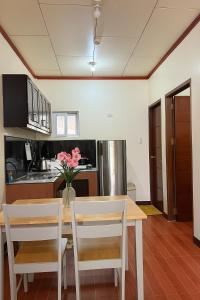a kitchen with a table and chairs with pink flowers at Audi's Serviced Apartment in Puerto Princesa City